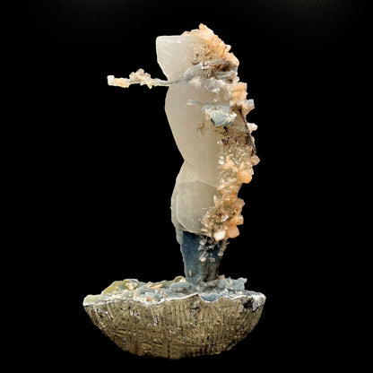 Towering calcite specimen coated in chalcedony and stilbite with a single distinctive, delicate stalactite growing sideways near the top termination, with stilbite blades of its own. The base is blue chalcedony stalactites with basalt on the bottom.